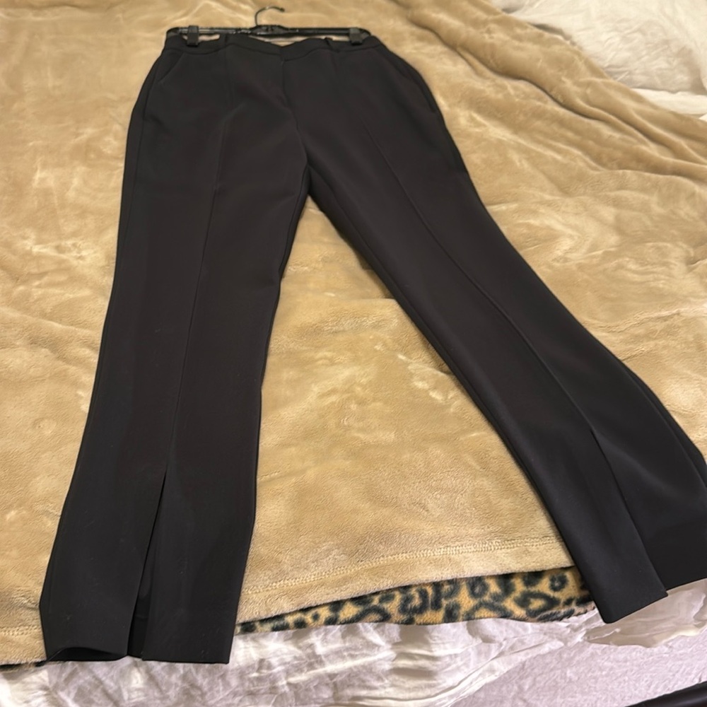 Black pants with a fashionable slit in the middle of the hem on the front.